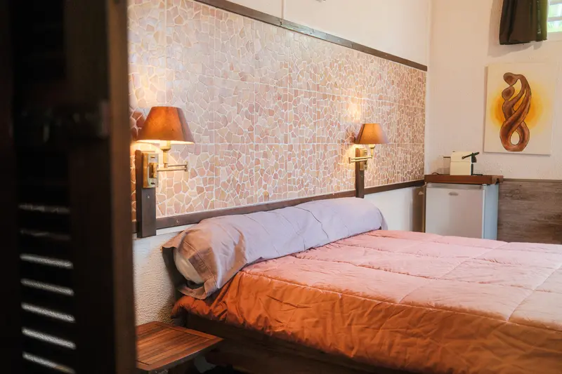 Chambre du bungalow avec mur en mosaïque et appliques