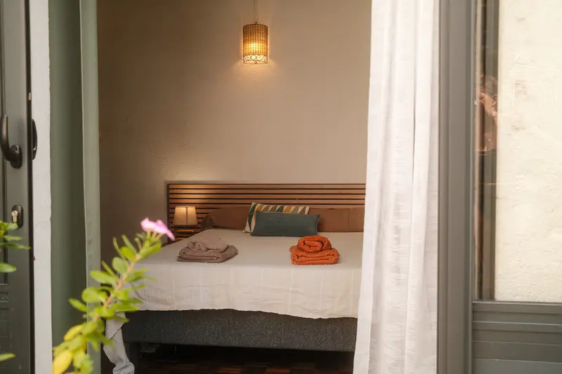 Chambre vue depuis la terrasse avec rideaux blancs