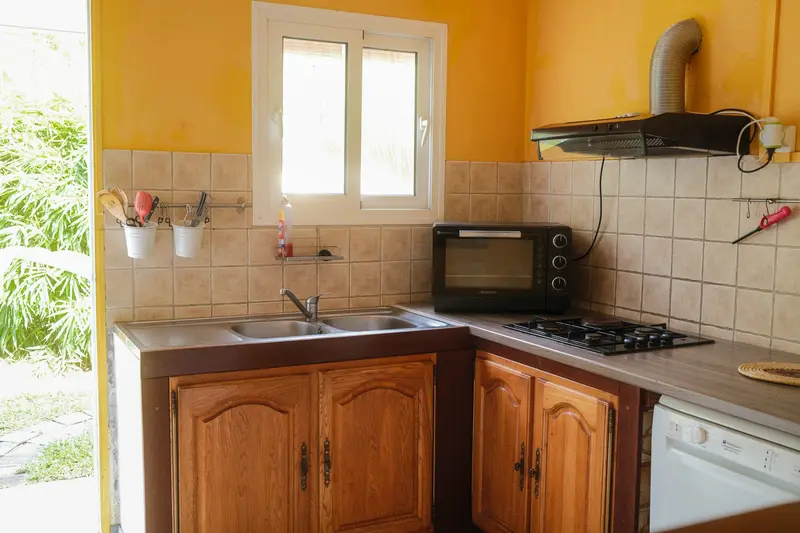 Cuisine équipée avec meubles en bois et vue sur le jardin