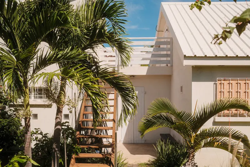 Façade de la villa entourée de palmiers