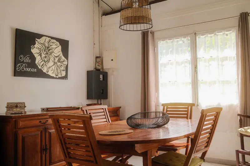 Salle à manger avec table en bois et suspension en rotin