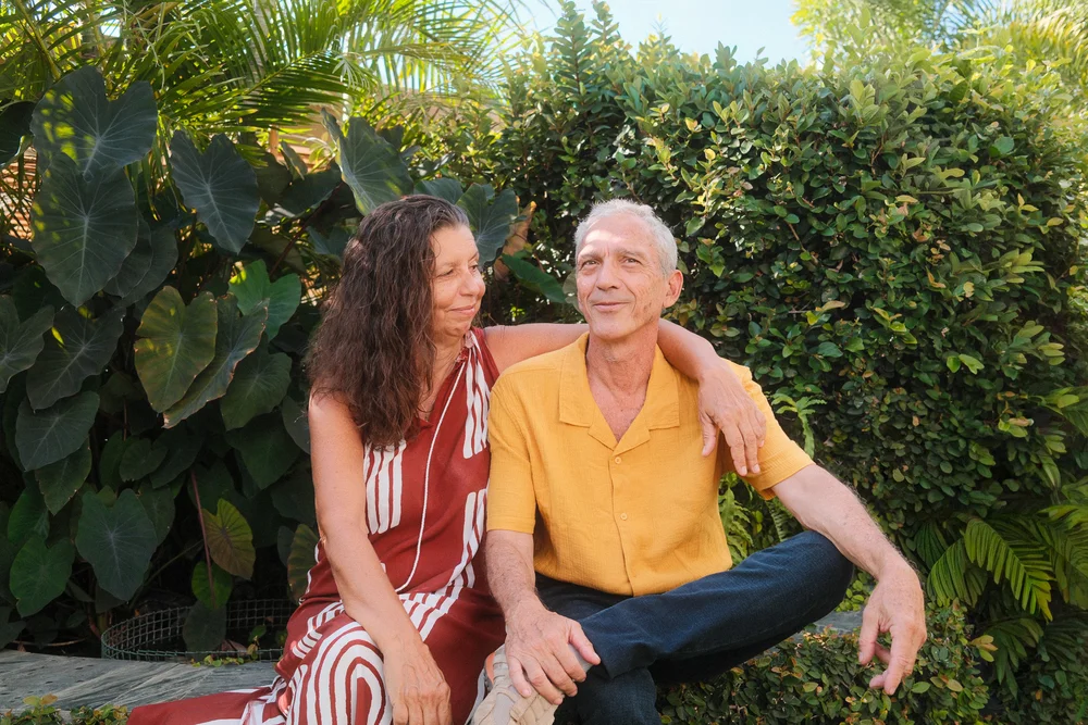 Elisabeth et Pierre, vos hôtes à la Villa Boucan, assis dans leur jardin tropical